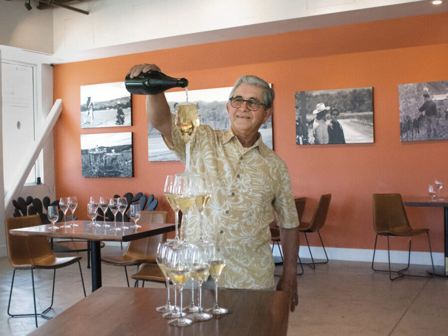 Mario Bazan pouring sparkling wine into a tower of stacked wine glasses