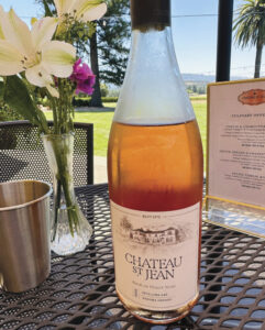 bottle of Chateau St. Jean rose on outdoor table with flowers