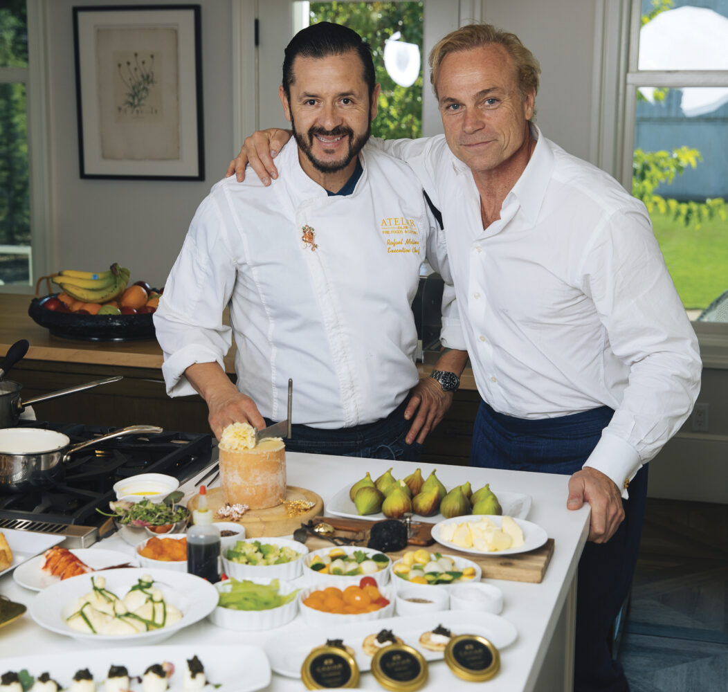 Chef Rafael Molina and Jean Charles Boisset standing near display of fine food in white shirts with arm around each other