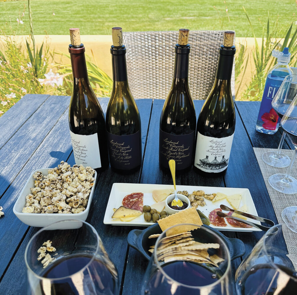 bottles of wine and plates of food on outdoor table at Landmark Vineyards Tasting