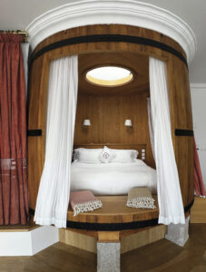 bed with white curtains and wood paneling surround
