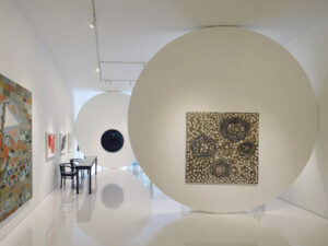 Interior of art gallery with art on white walls with white floors