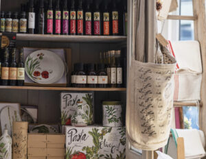 store display of various olive oils, grapeseed oils, dishes, bags and gifts