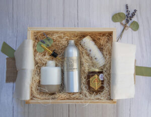wooden box with neutral toned gift items such as body wash, candle, etc