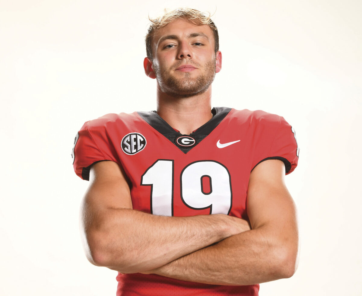 University of Georgia football player Brock Bowers in uniform with arms crossed on white background
