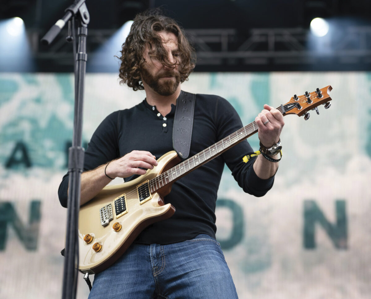 Ian Devereux on stage playing the guitar at Bottlerock