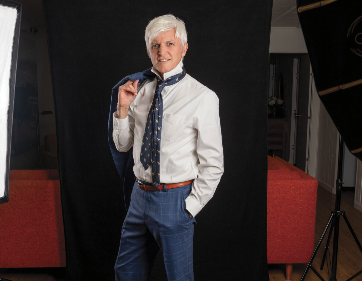 Photographer Tim Carl in suit and tie with jacket over shoulder in front of 