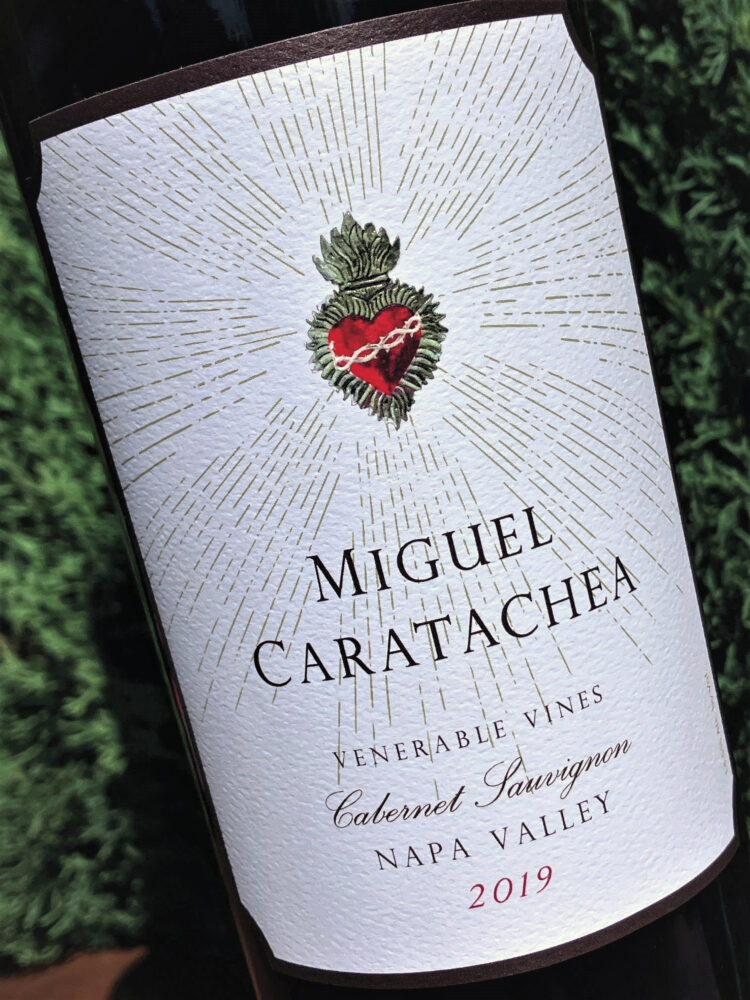 bottle of wine with white label with logo for Miguel Caratachea