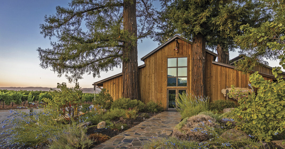 Exterior view of the tasting room at Sequoia Grove with wood panels, vineyard view with trees in the foreground