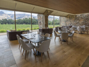 Interior Tasting Room of Stag's Leap Wine Cellars with tables and chairs on wood floors with full length windows looking out to mountain view