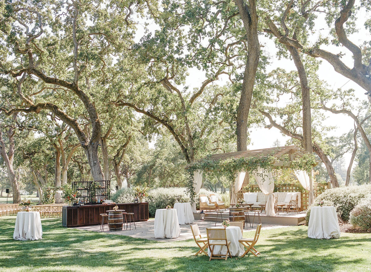 outdoor setting with tables with white tablecloths, chairs, flowers, a wooden bar at Silverado Resort
