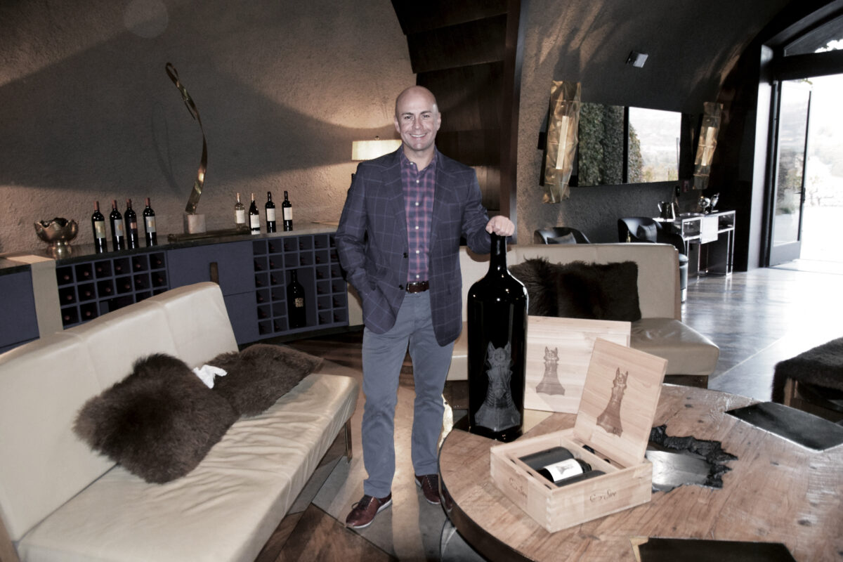 Thomas Buck standing in room with large bottle of Sire wine
