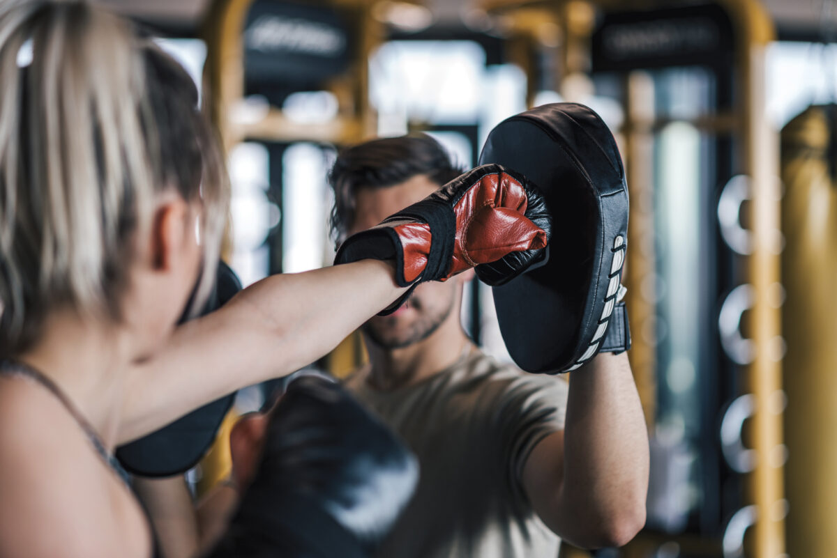 Woman boxer hitting the glove of her sparring partner, close-up.