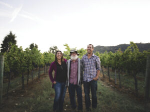 woman and two men stading in vineyard