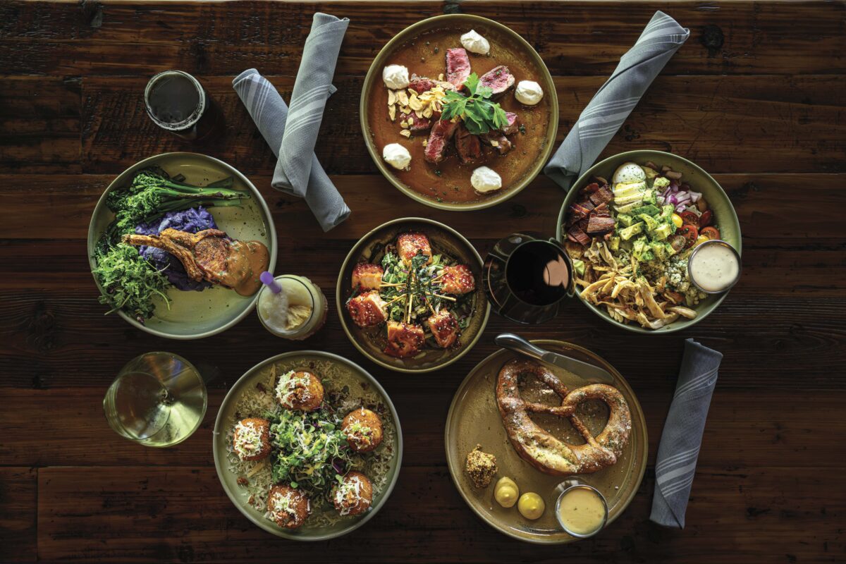 overhead view of plates of food on wooden table 