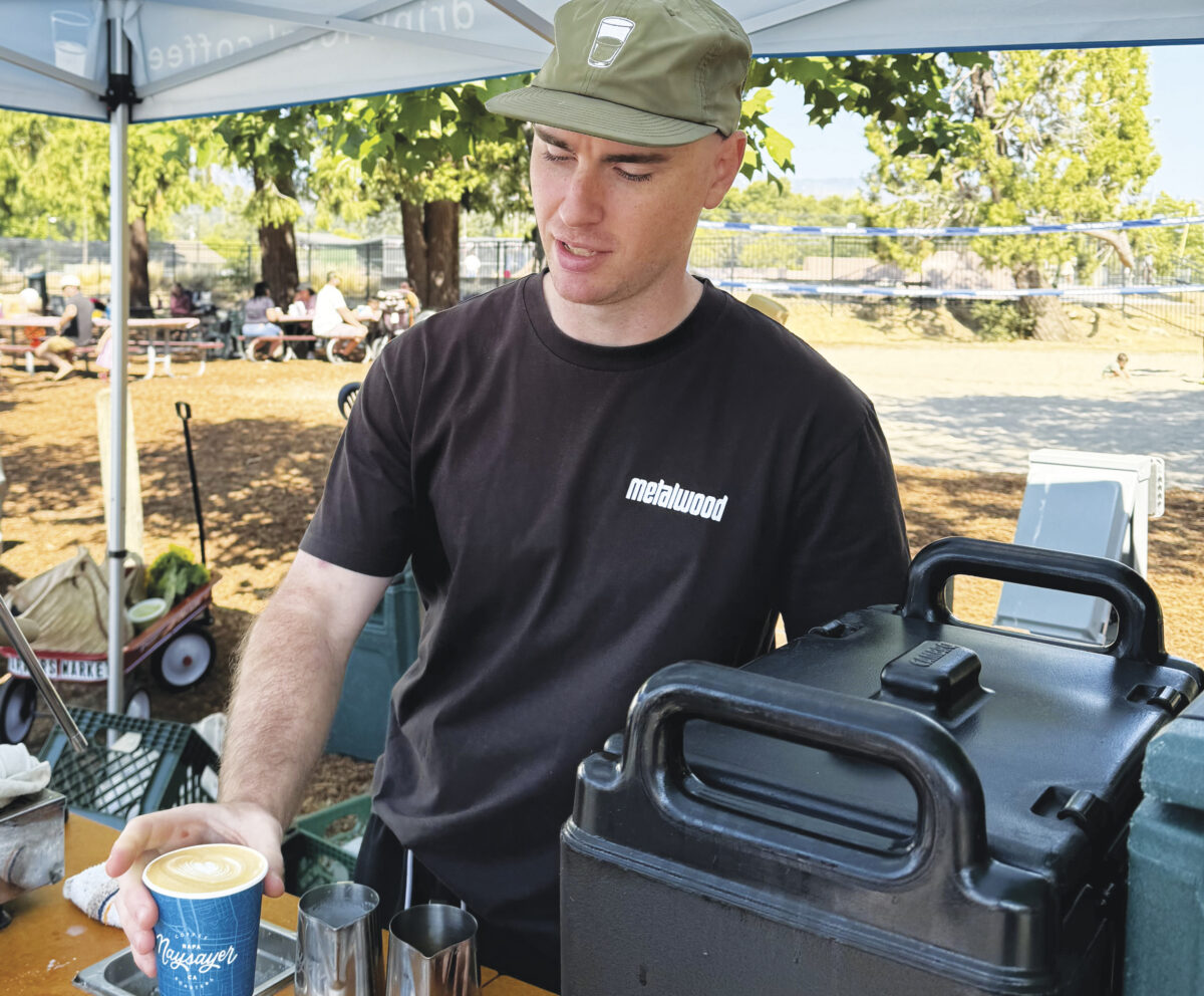 man serving coffee under tent