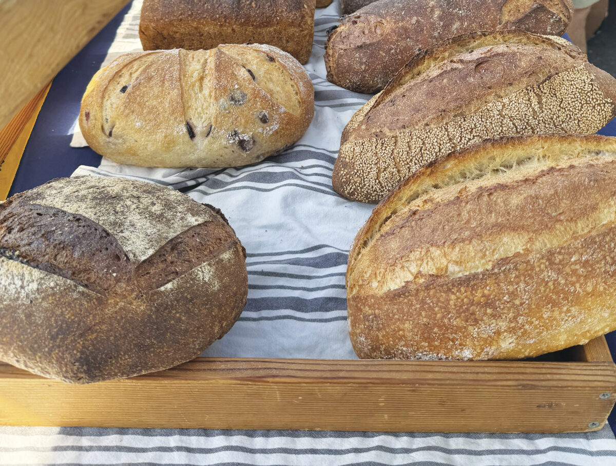 loaves of bread on towel with wood fram