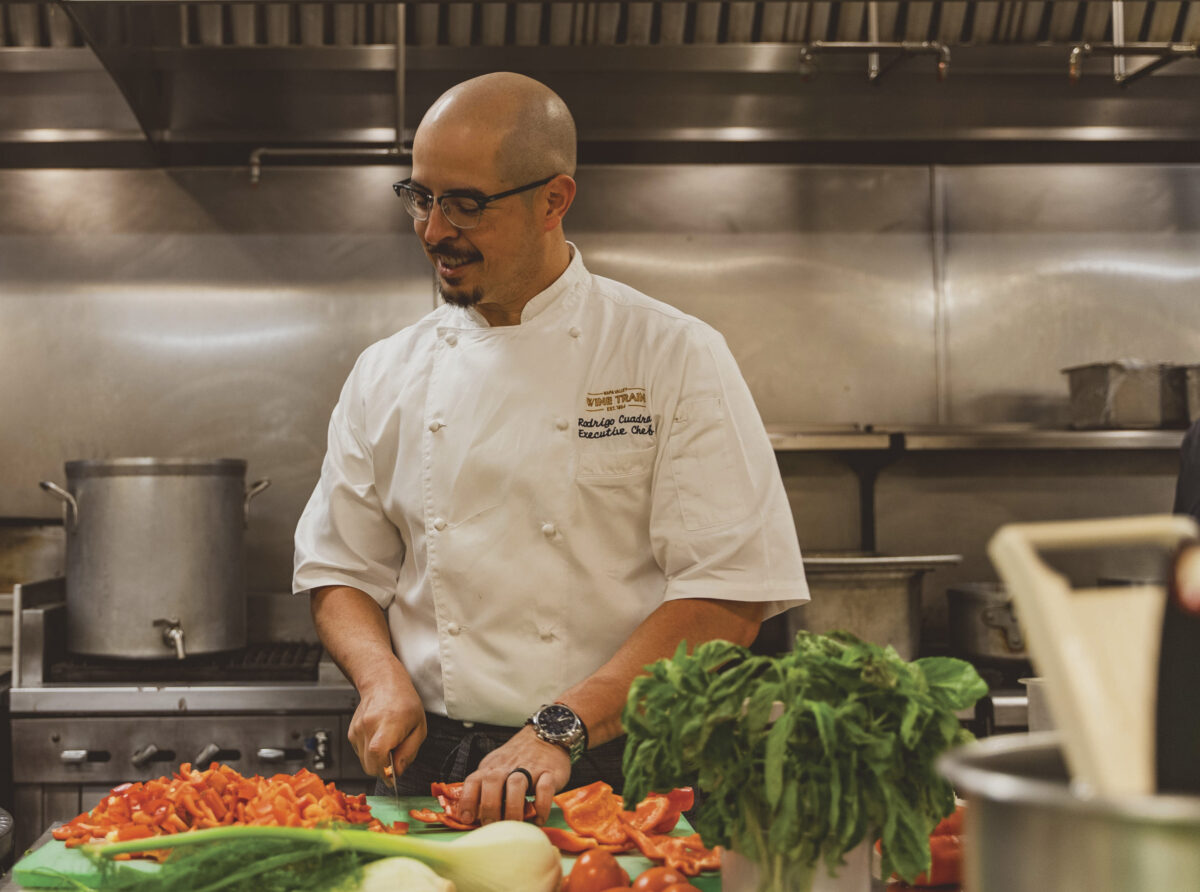 Napa Valley Wine Train Executive Chef Rodrigo Cuadra in kitchen, chopping vegetables, smiling