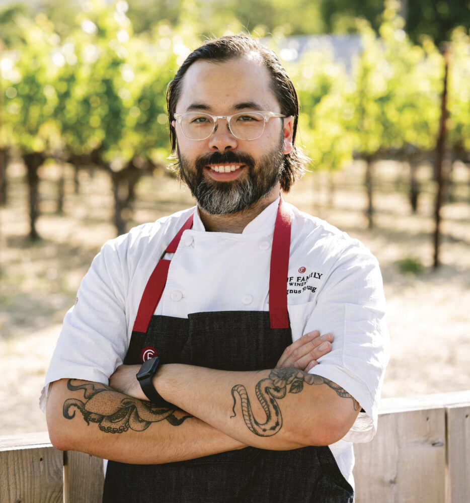 Clif Family Winery’s Executive Chef Magnus Young wearing chef's apron, smiling with arms crossed for article Culinary Crossroads