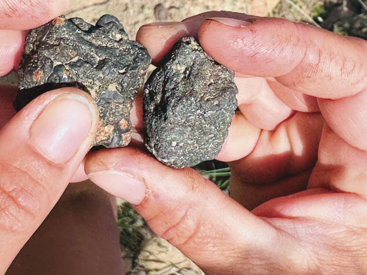 hands holding dark stones for the article Heroic Vineyards