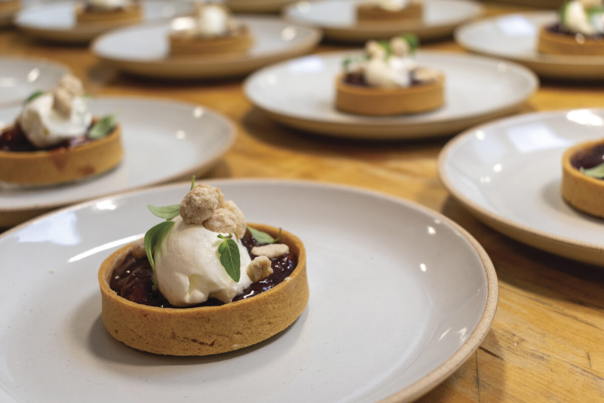 rows of white plates on wood table with small circular desserts at lunch at Somerston Estate Winery