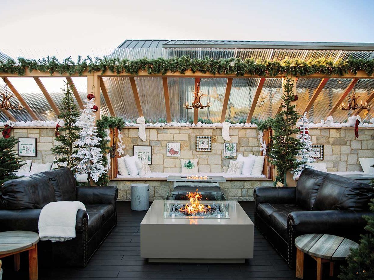 exterior patio with fire pit and holiday decor with leather seating at Winter Chalet at Truss Restaurant and Bar Photo courtesy of the Four Seasons Napa Valley