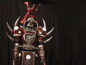 Mario Chiodo sculpture called Creature: Red Samurai made of silver and red metal with horns, industrial art for Napa Artist Mario Chiodo article