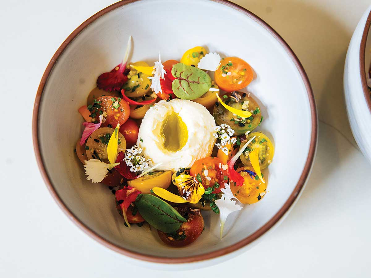 white bowl with fresh, colorful vegetables with soft white cheese in the center at Sequoia Grove