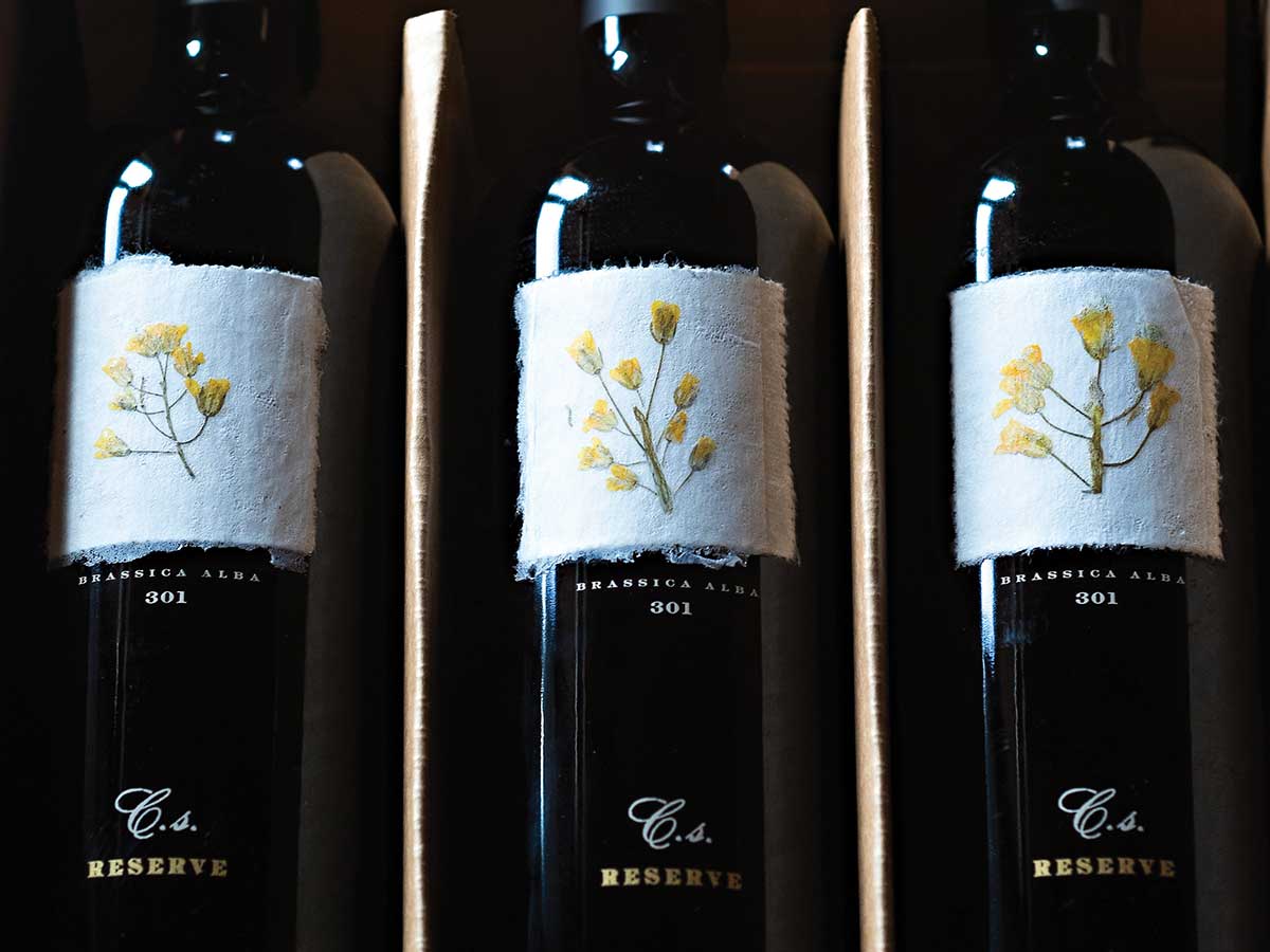 3 bottles of wine in box with white cotton label and yellow flowers for Reynolds Family Winery article