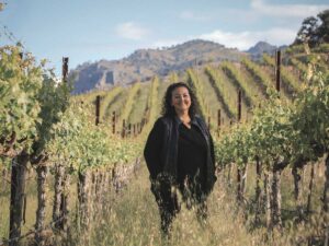 General Manager Elizabeth Vianna of Chimney Rock standing in vineyard. wearing black, smiling