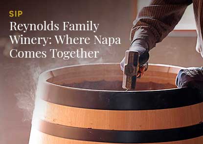 Man playing a piano outside. Two women walking with a dog