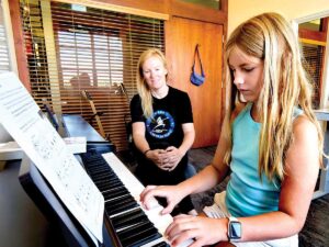 child playing the piano with adult piano teacher sitting nearby at Napa School of Music