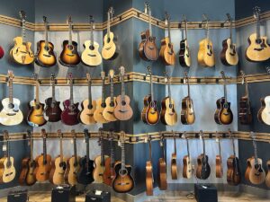 wall of guitars on gray background at Tonewood & Courage in Napa